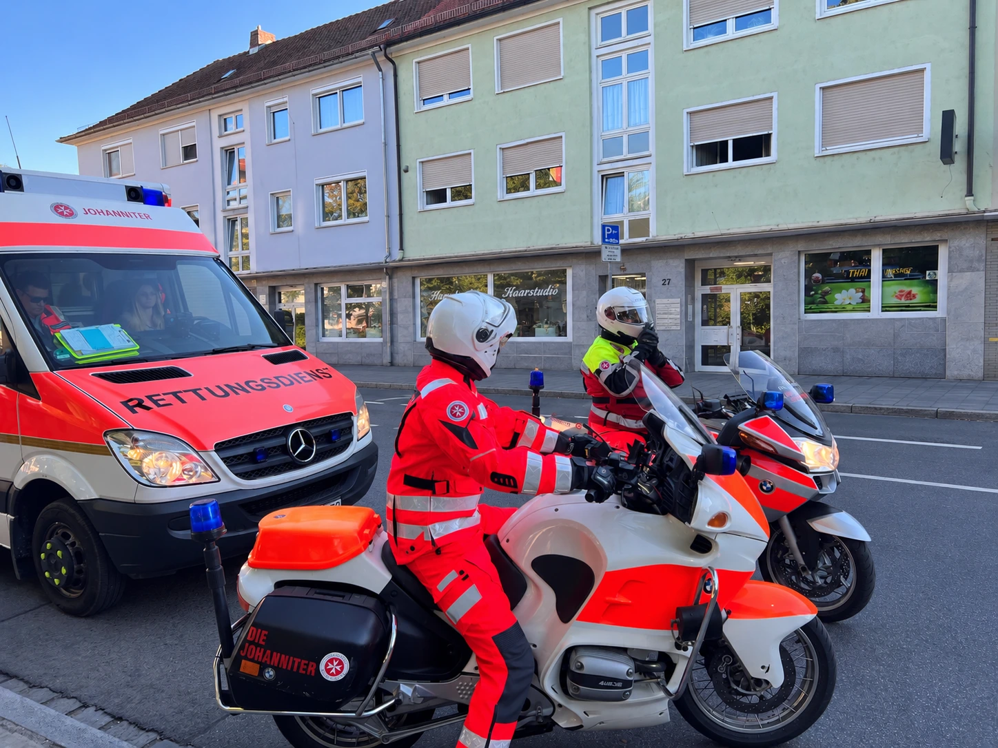 Zwei Einsatzkräfte der Johanniter-Motorradstaffel auf ihren Motorrädern am Gartenstädter Markt
